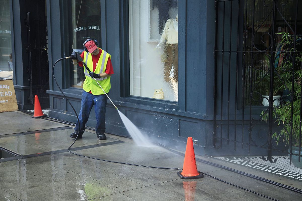 Mixed use building in Gastown a man power washing the building and streets