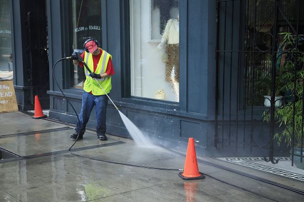 Mixed use building in Gastown a man power washing the building and streets