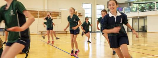 Students participate in a Physical Education lesson on the gym court.