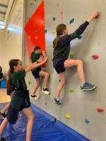 Students boulder on the climbing wall in our gym.