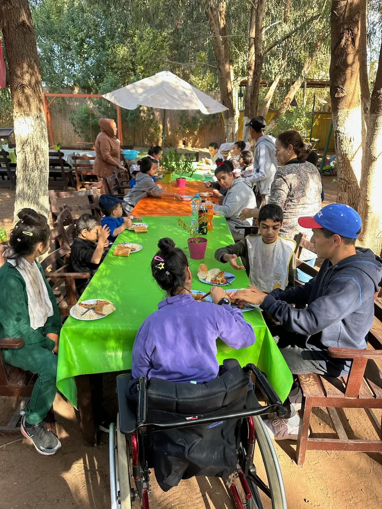 Un repas en plein air autour d’une grande table, à l’ombre des arbres