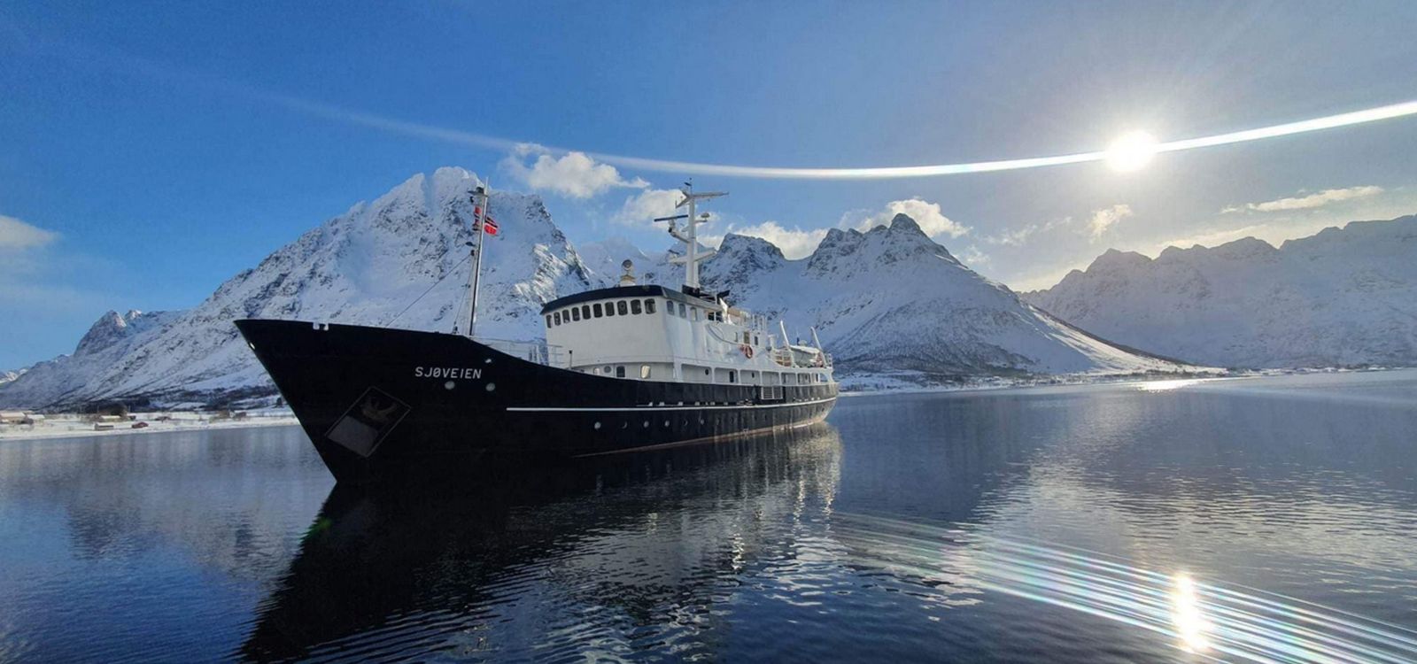 M/S Sjøveien beneath Arctic mountains