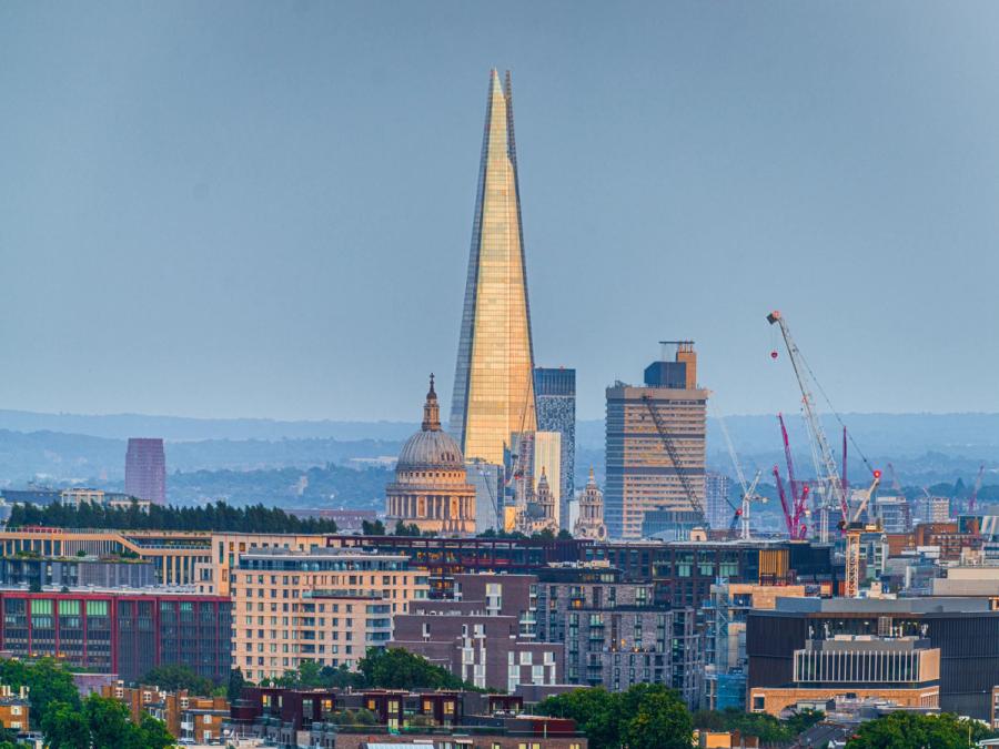 Golden Light reflects off the Shard in London, with St Pauls Cathedreal standing beside it from the viewpoint of Parliament Hill.