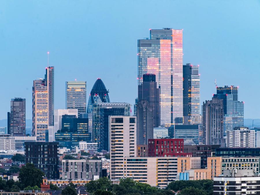 The red light of sunset reflects off 22 Bishopsgate in London, alongside the Gherkin and other skyscrapers in the City of London.