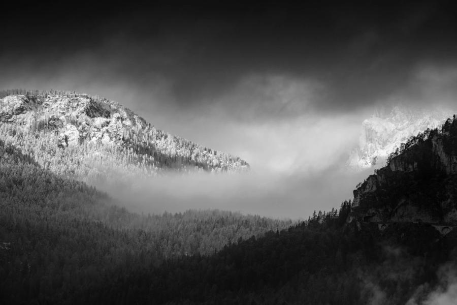Sunrise in the Dolomites never ceases to amaze. Low clouds rolled down the steep banks of the mountains during this morning, where sunrise light bathed the distant scene, but left higher clouds and the foreground in deep shadow. This created a letter box style of framing over the vast forest visible here. Taken from our hotel balcony in the town or Cortina.