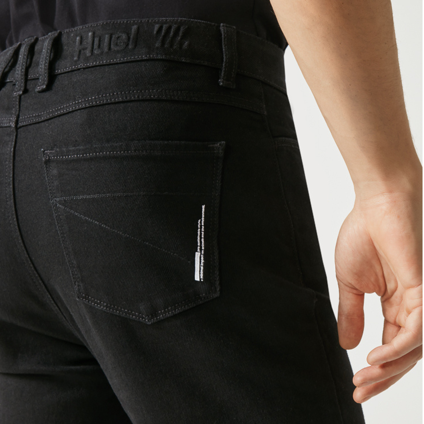 A close up of the back pocket of mens black jeans