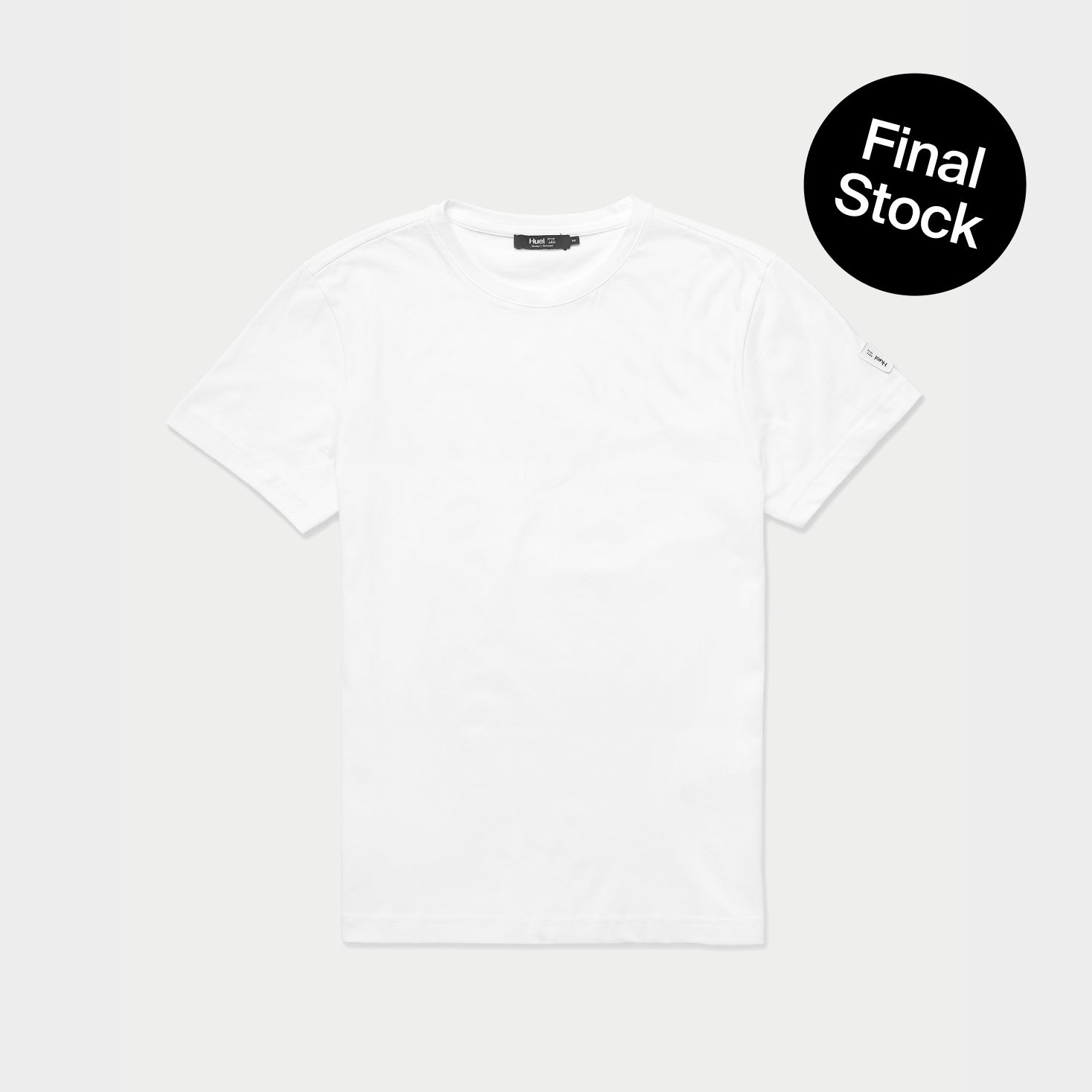 A plain white Huel t-shirt flat on a beige background