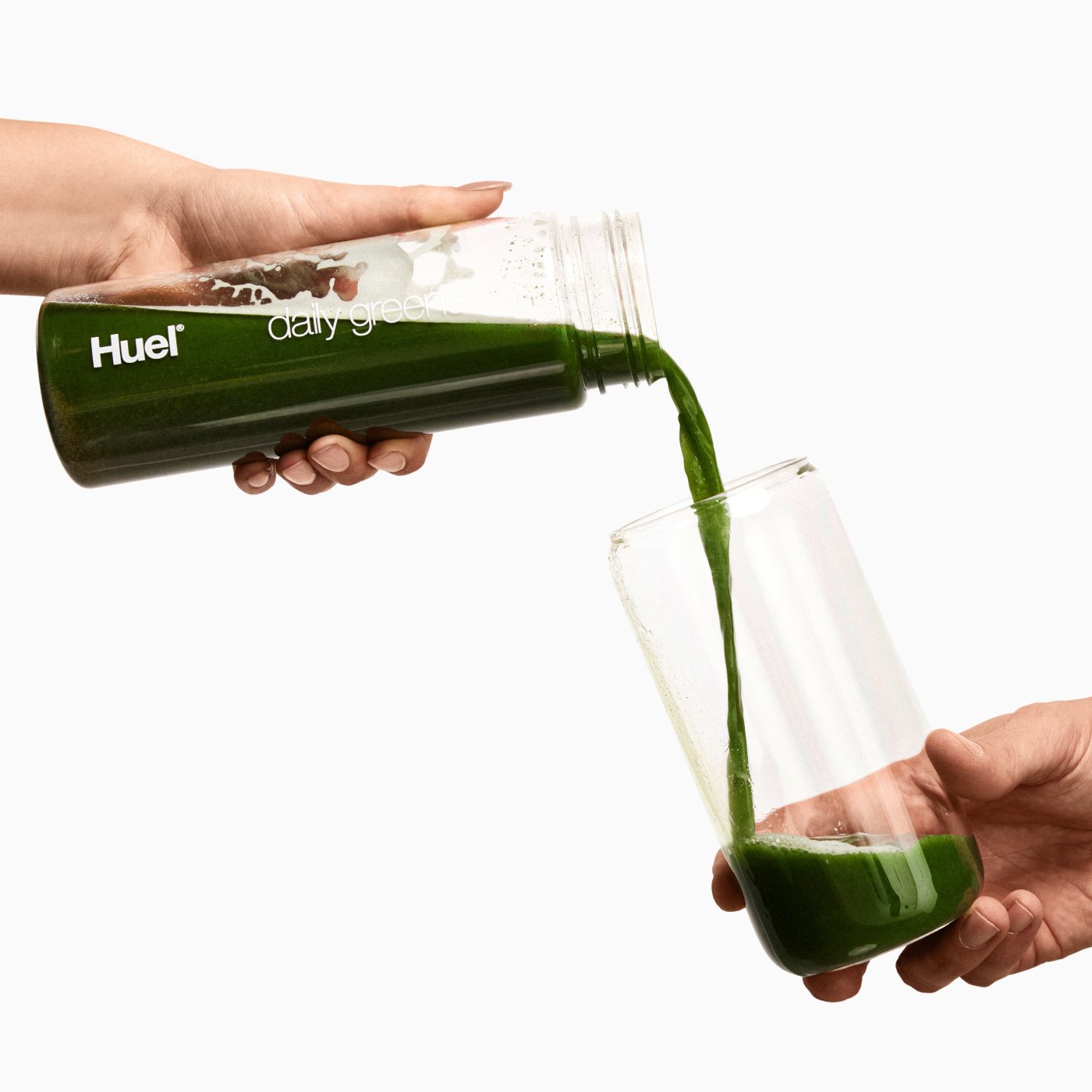 Pouring a scoop into Greens clear bottle