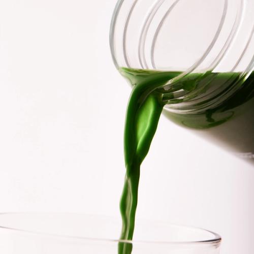 Extreme close-up on Huel Daily Greens drink pouring from a clear Huel Daily Greens Bottle