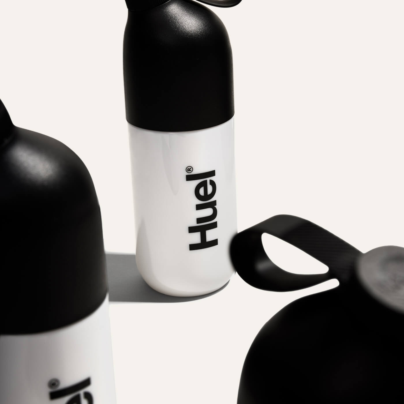 Black and white Huel Shaker surrounded by other Huel Shakers