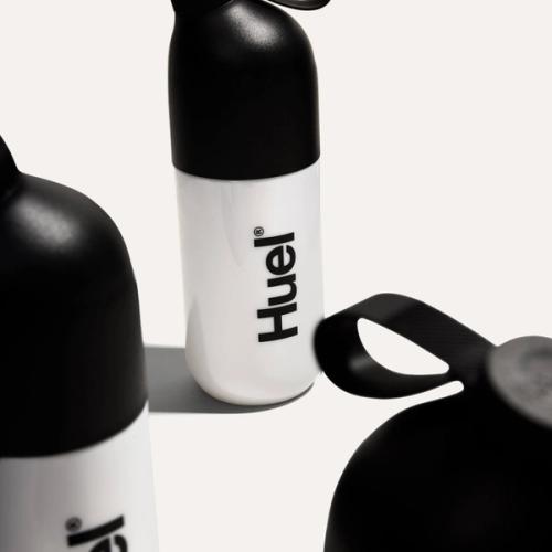 Black and white Huel Shaker surrounded by other Huel Shakers