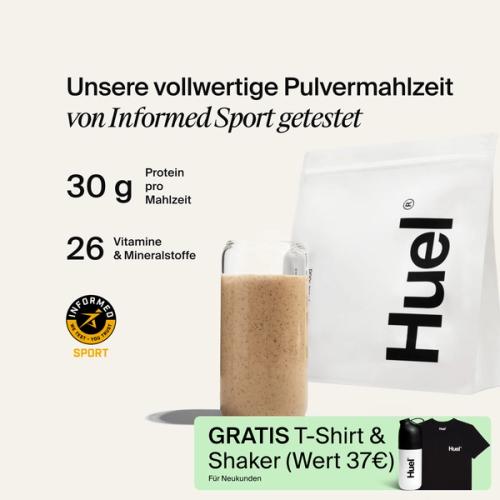 Ein Beutel Huel Pulver neben einem Glas mit einem Huel Drink vor einem neutralem Hintergrund