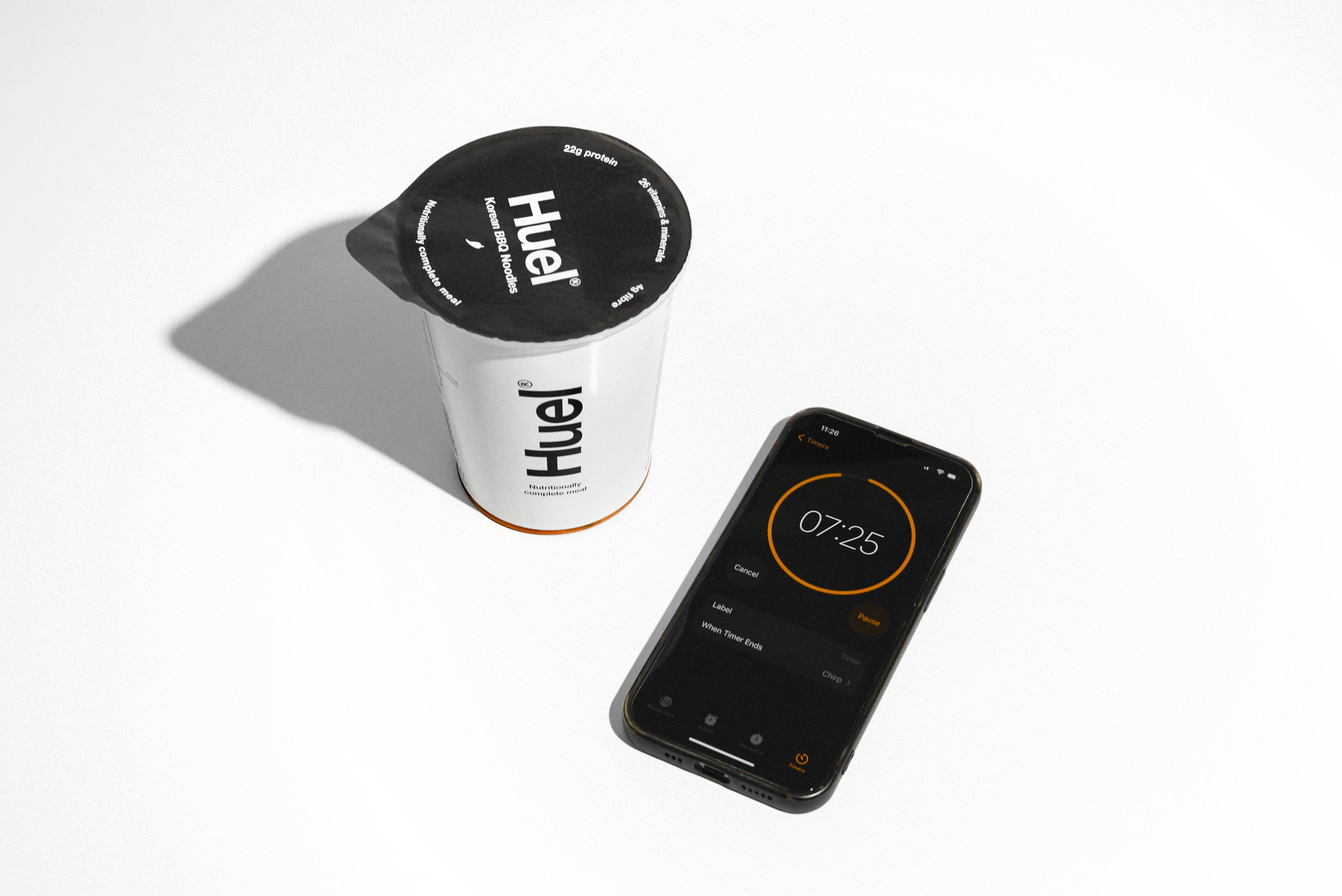 A Huel pot next to a 5-minute timer on a phone