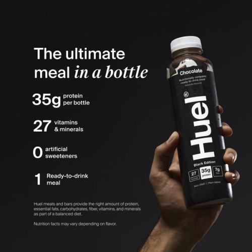 A hand holding a bottle of Huel Black Edition ready-to-drink on a black background