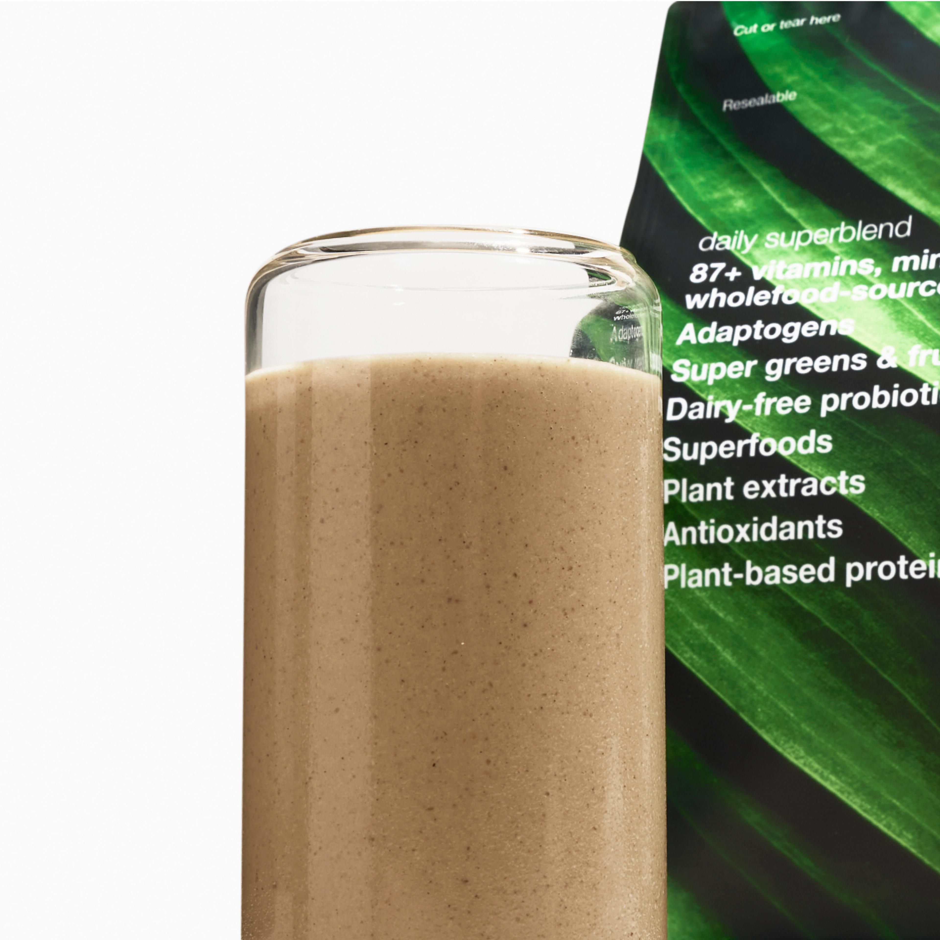 An image of prepared Superblend in a glass cup, with the Superblend pouch behind it. 