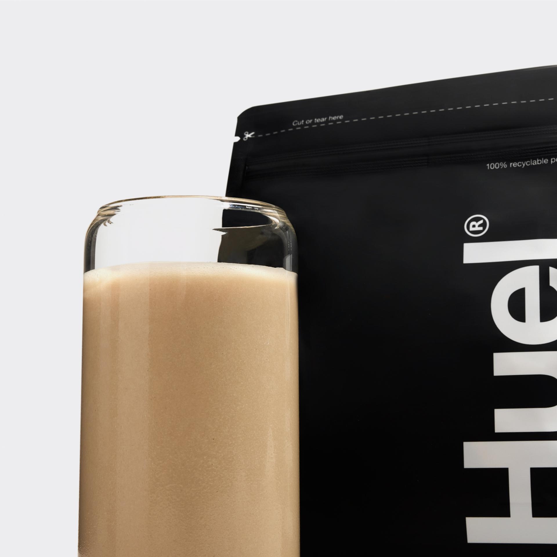 Ein Glas Complete Protein vor dem Complete Protein-Beutel