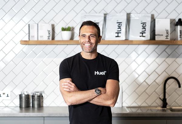 Uma imagem de Julian Hearn, o fundador da Huel, de braços cruzados e a sorrir.