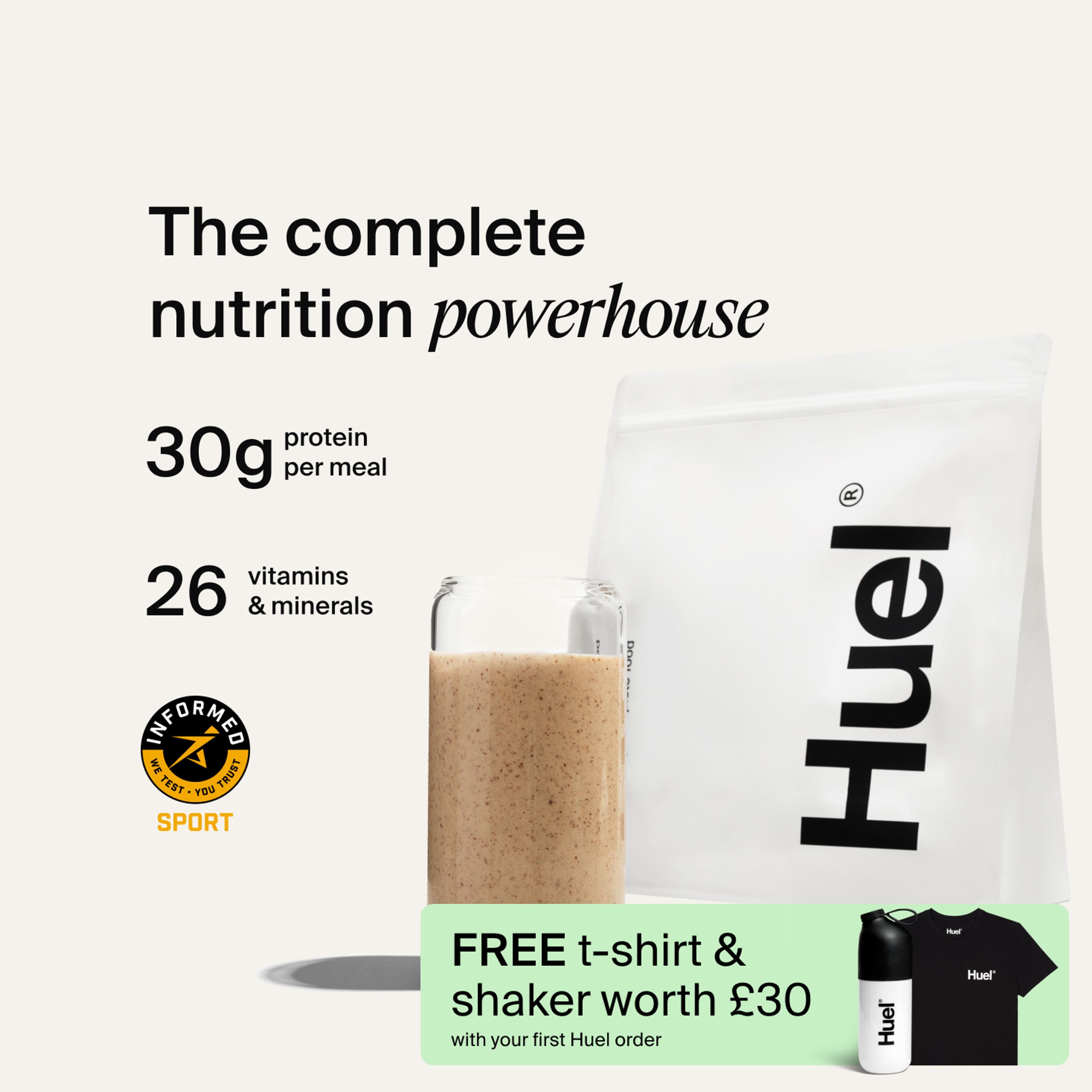 A bag of Huel professional powder next to a glass containing a Huel drink on a neutral background