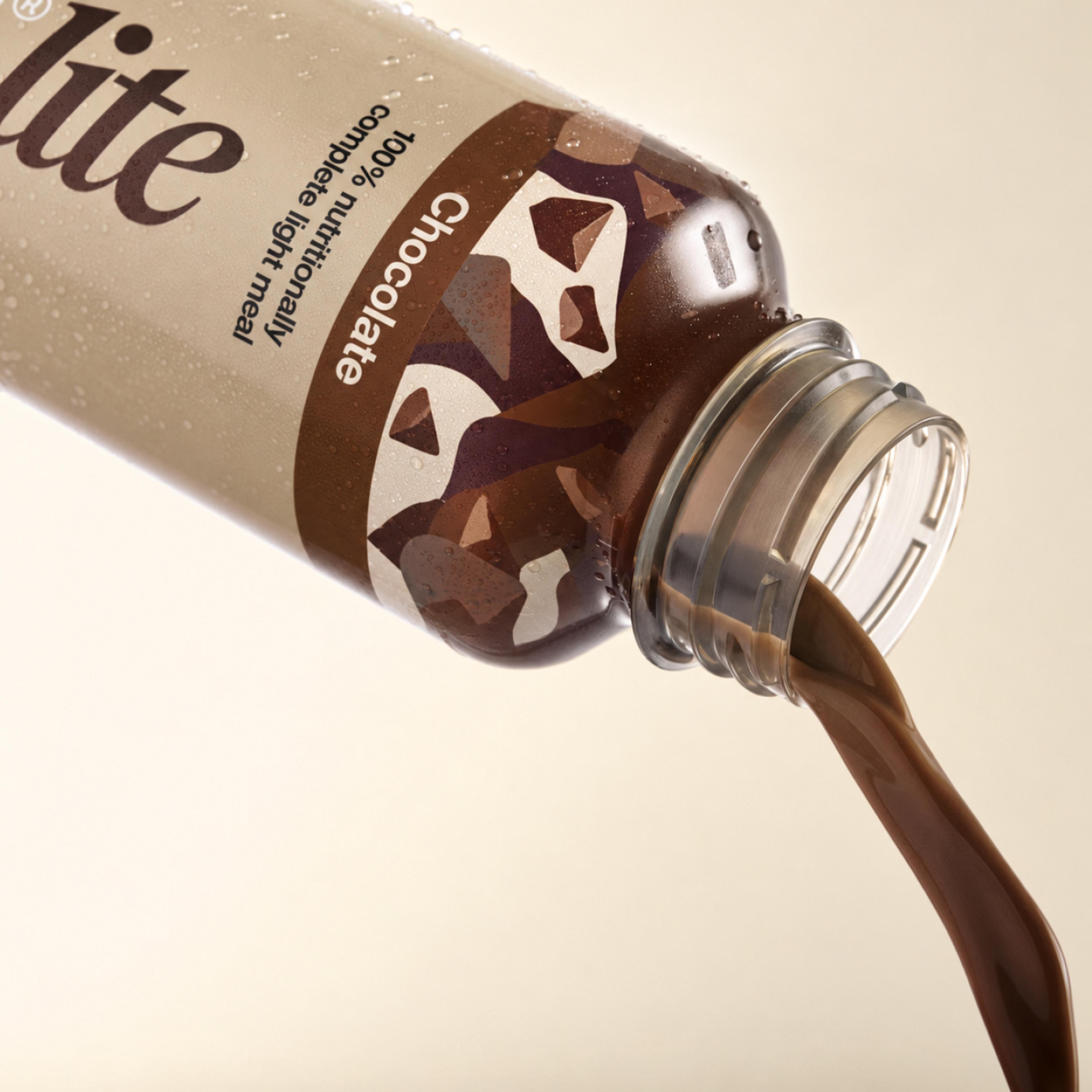 Huel chocolate pouring from a bottle of Huel Ready-to-drink lite on a beige background