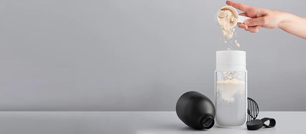 scoop of huel powder being poured into a huel shaker