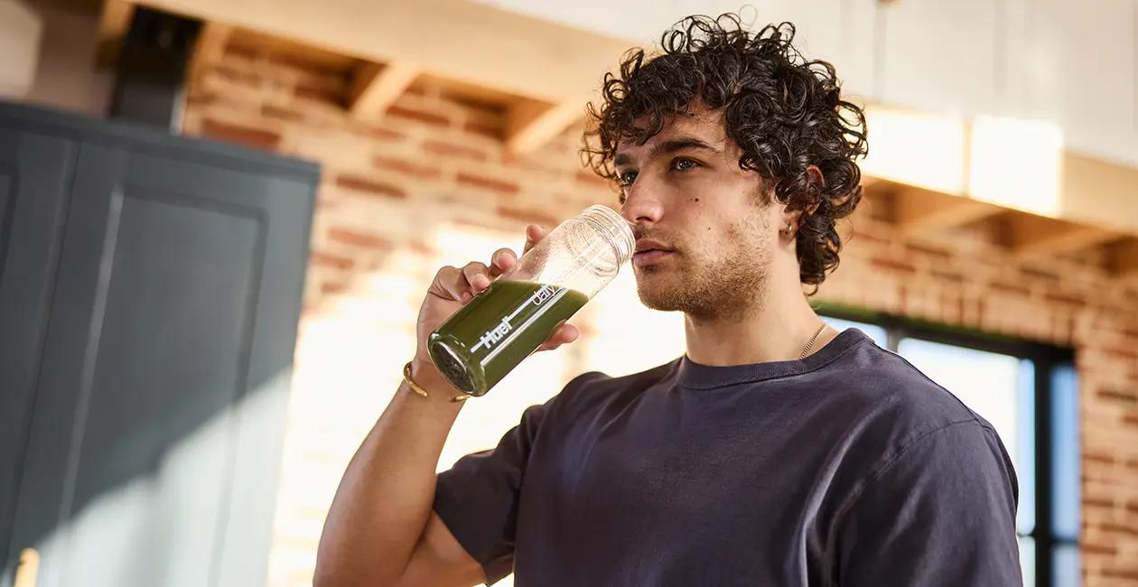 man drinking Huel Daily Greens from a Huel bottle