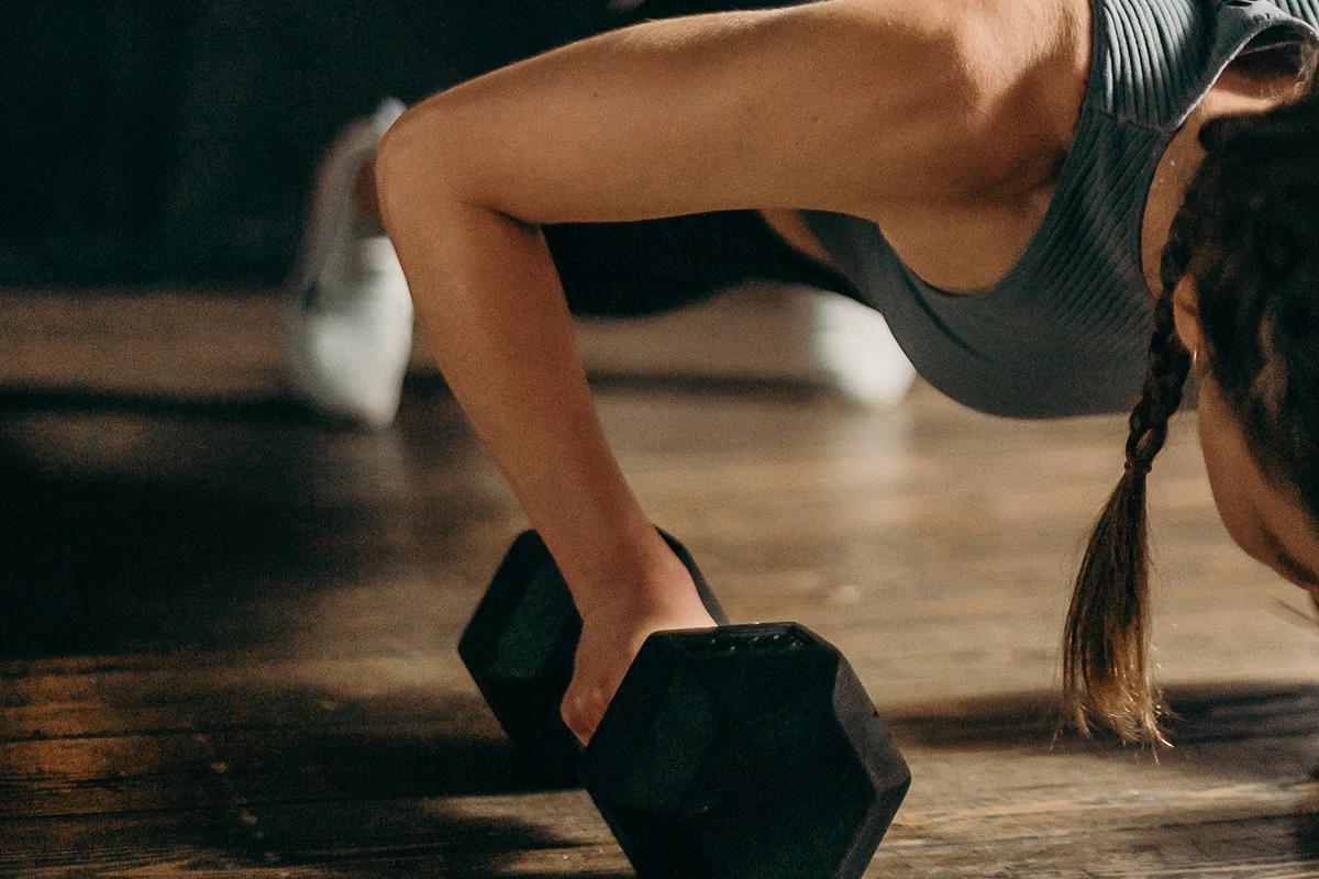 woman doing a press up using a hexagon dumbbell