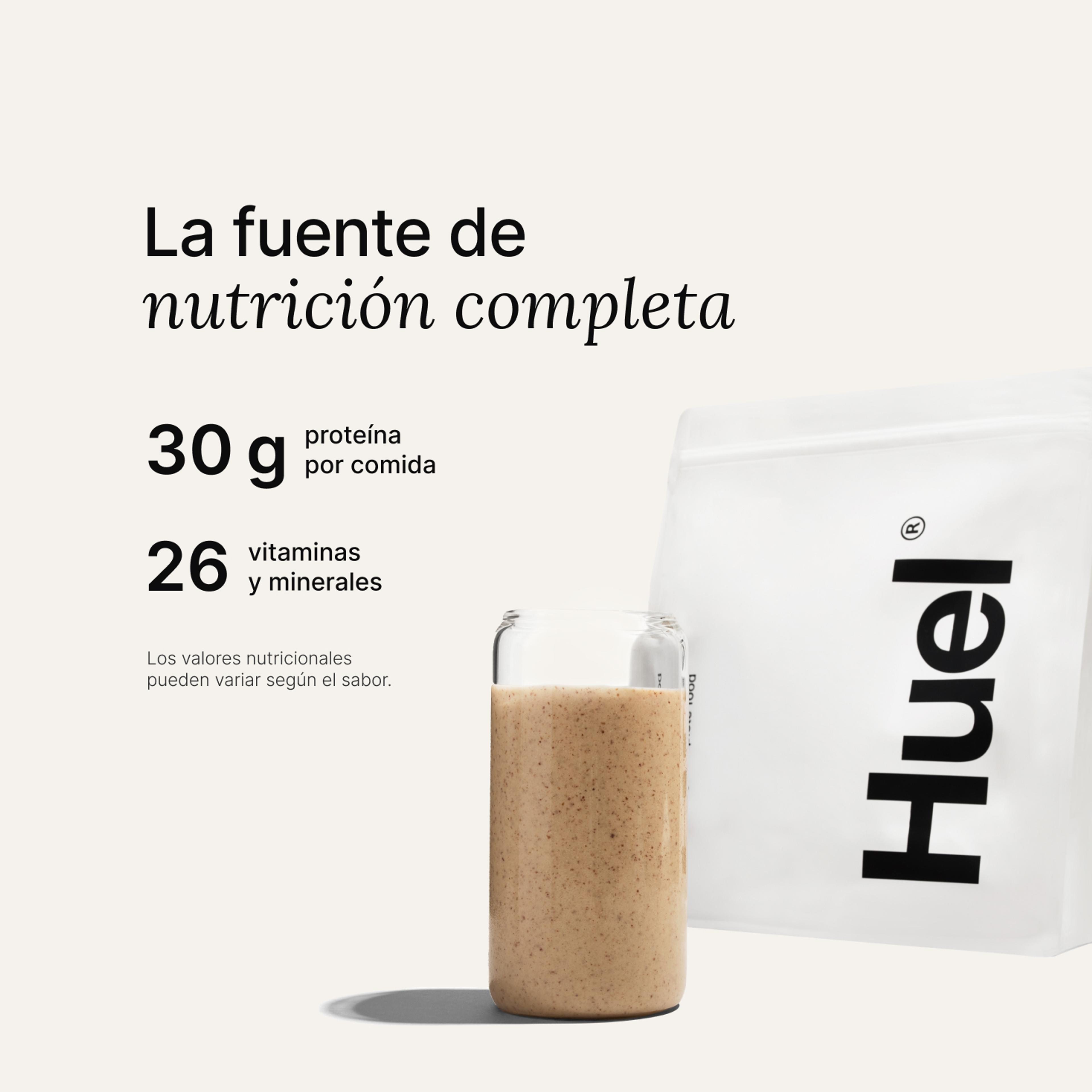 Una bolsa de Huel Powder junto a un vaso que contiene una bebida de Huel sobre un fondo neutro