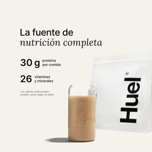 Una bolsa de Huel Powder junto a un vaso que contiene una bebida de Huel sobre un fondo neutro