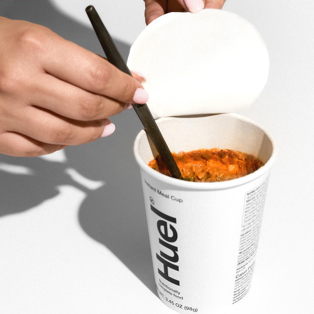 Someone stirring a pot of Huel Hot & Savory Noodles