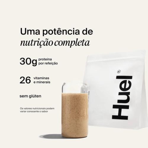 A bag of Huel powder next to a glass containing a Huel drink on a neutral background