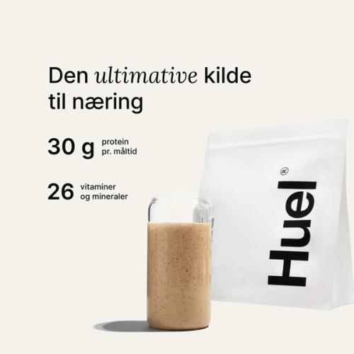 En pose med Huel-pulver ved siden af et glas med en drik fra Huel på neutral baggrund
