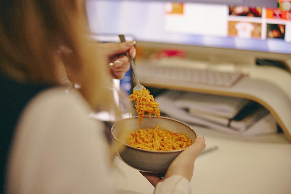 Woman eating pasta out of a bowl