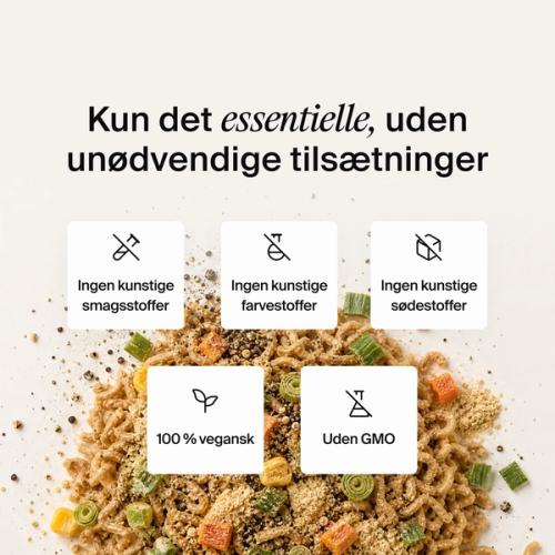 Tørrede grøntsager, krydderurter og nudler blandet sammen på en neutralfarvet baggrund