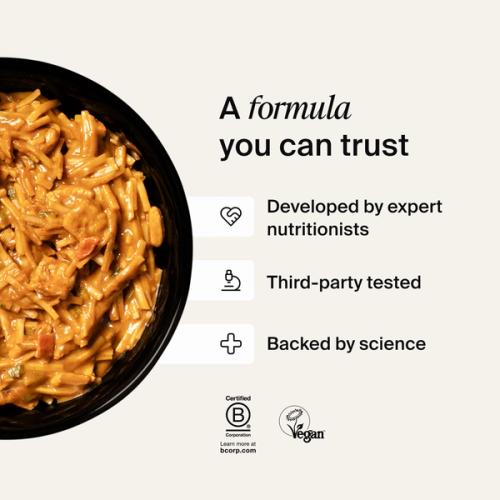 A bowl of Huel Hot & Savoury with fresh chilli and coriander on a neutral background