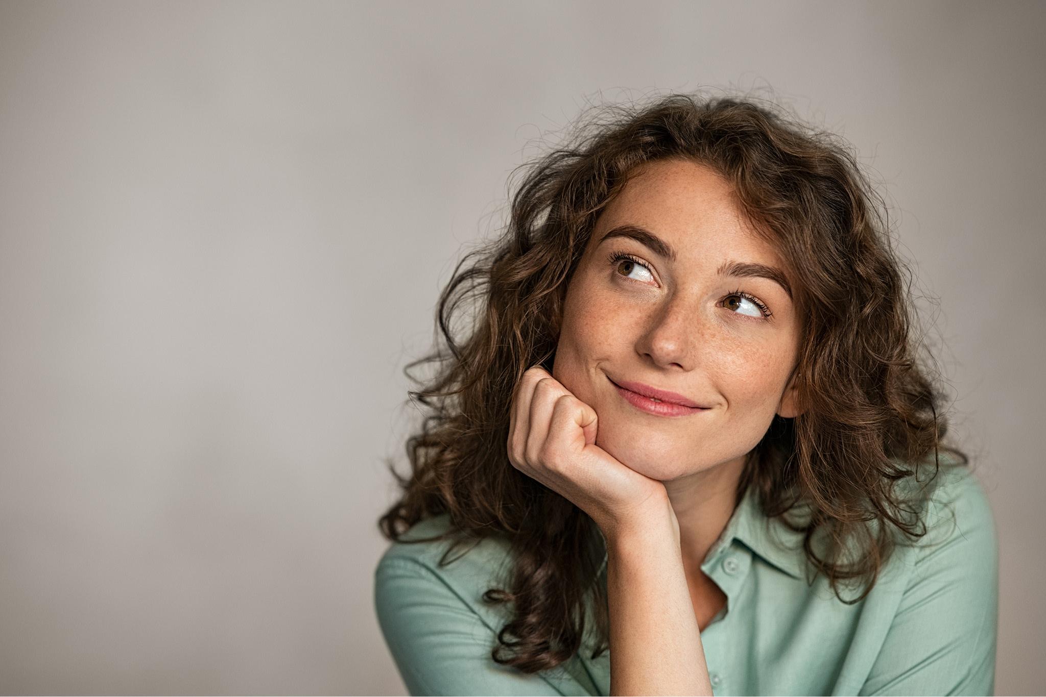 woman with her head resting on her hand thinking intently