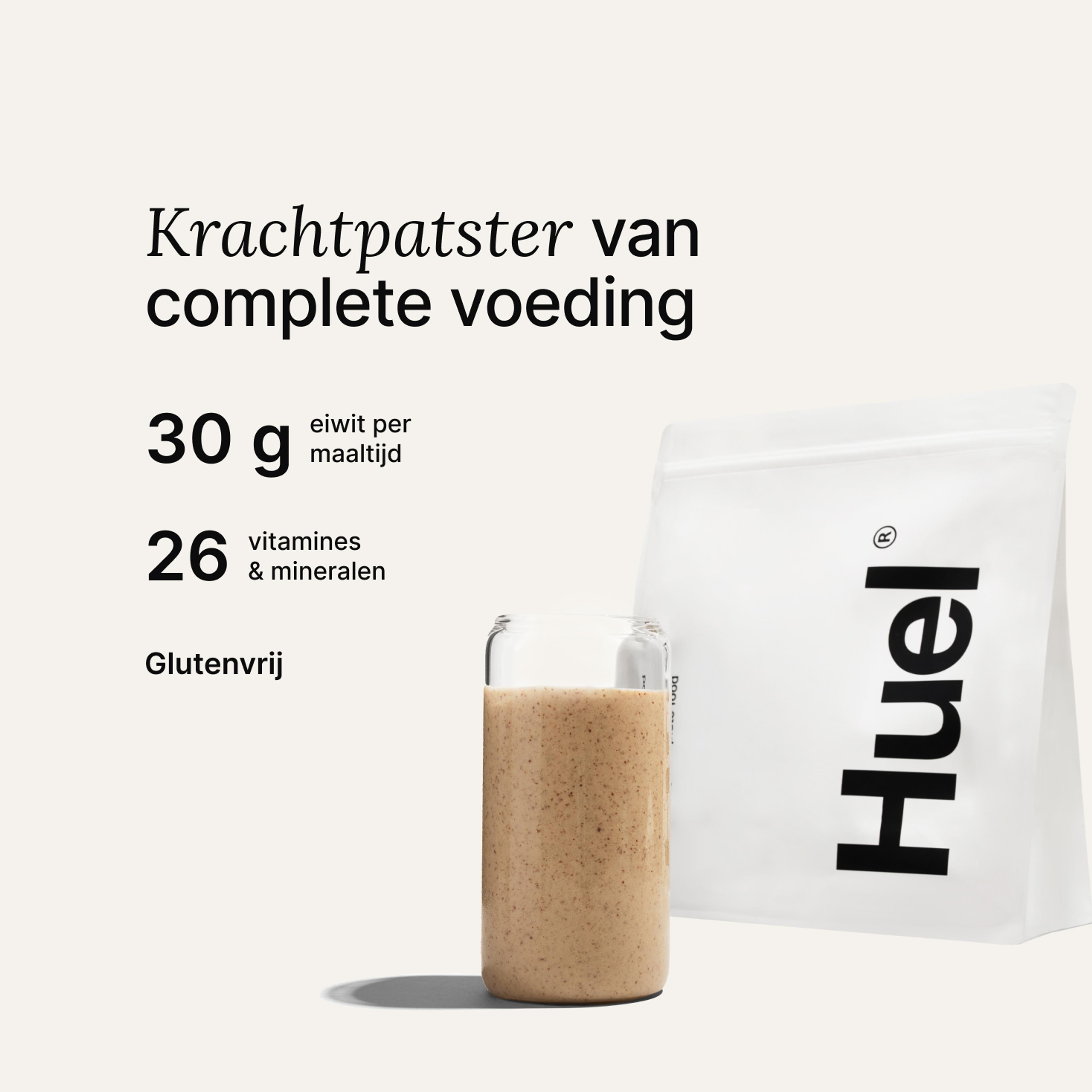 Een zak Huel-poeder naast een glas met een Huel-drankje op een neutrale achtergrond