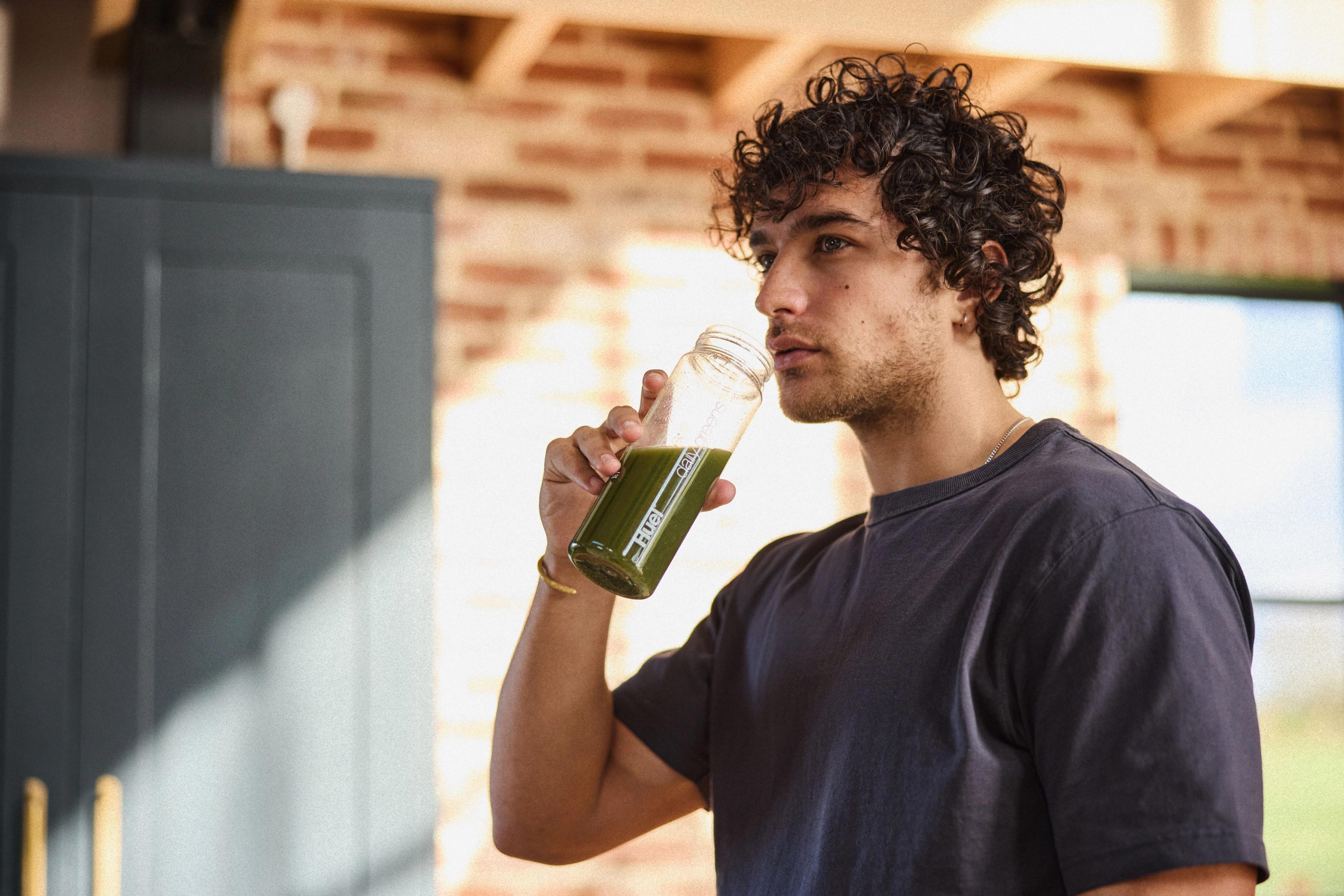 man drinking Huel Daily Greens