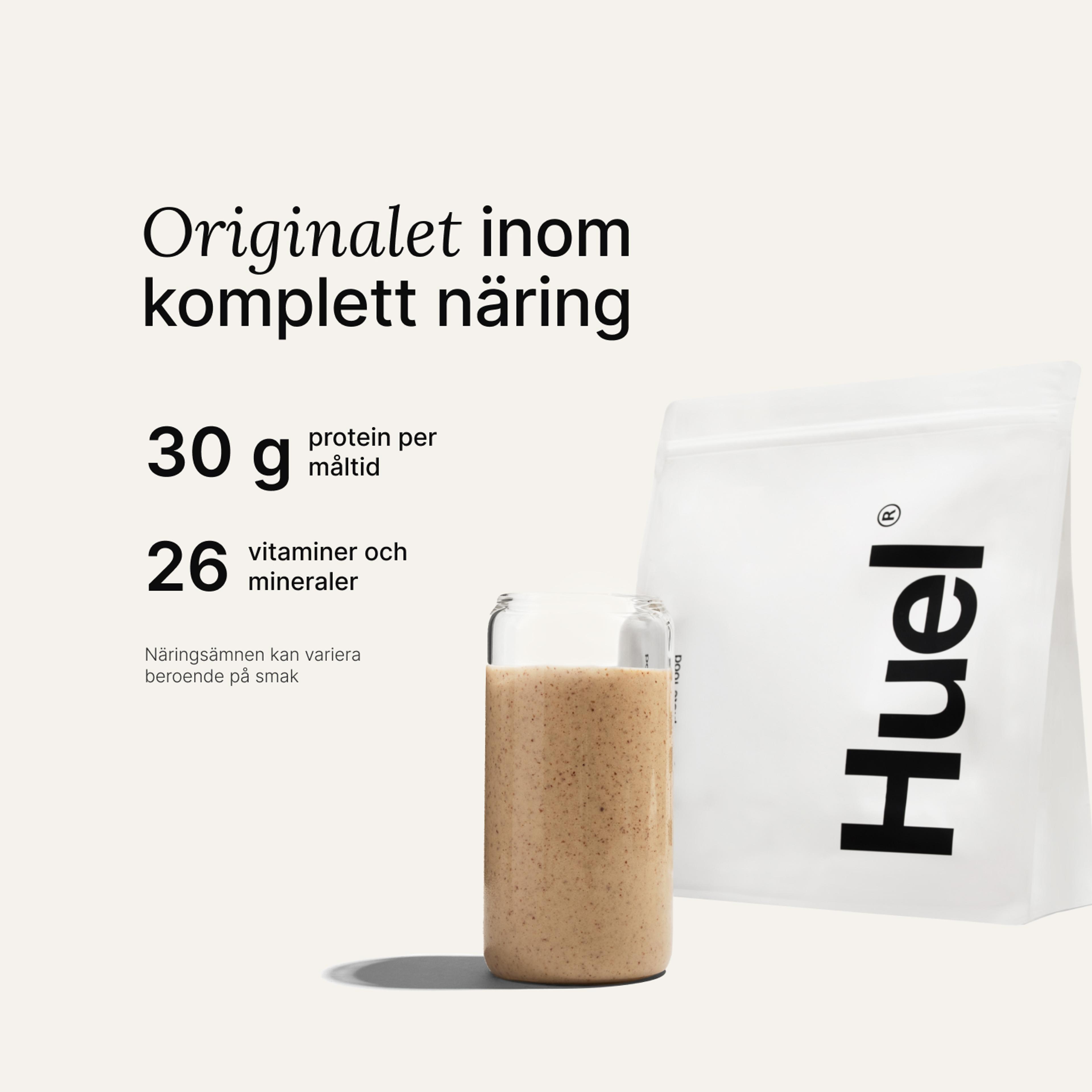 En påse Huel-pulver bredvid ett glas som innehåller en Huel-dryck på neutral bakgrund
