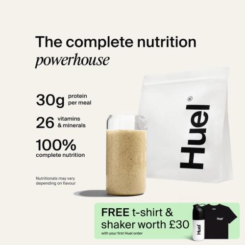 A bag of Huel powder next to a glass containing a Huel drink on a neutral background