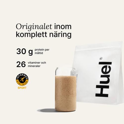 En påse Huel-pulver bredvid ett glas som innehåller en Huel-dryck på neutral bakgrund