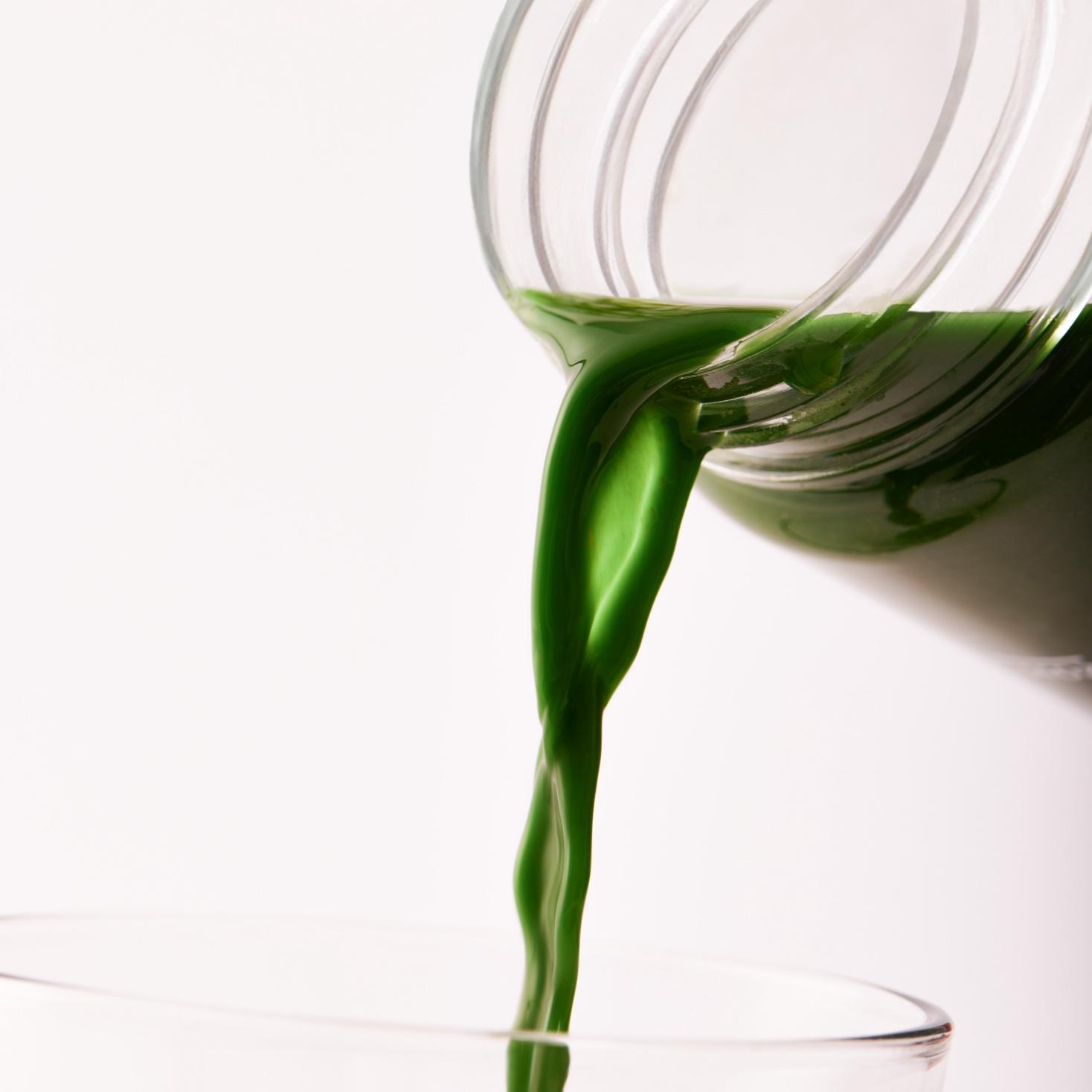 Extreme close-up on Huel Daily Greens drink pouring from a clear Huel Daily Greens Bottle