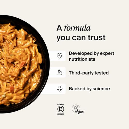 A bowl of Huel Hot & Savoury with fresh chilli and coriander on a neutral background