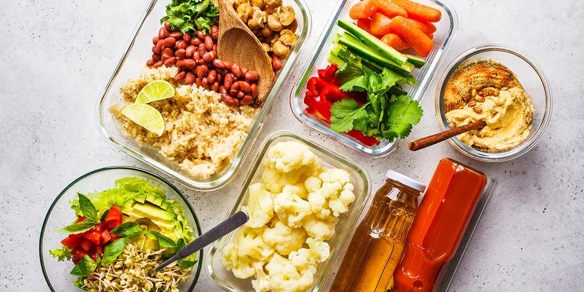 vibrant and colourful beans vegetables and grains in glass containers being meal prepped