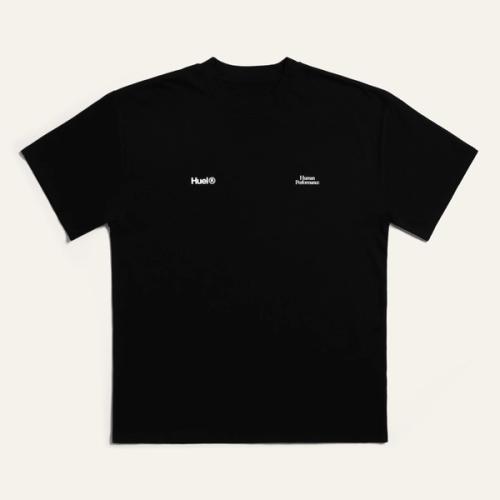 A black Huel t-shirt with a white 'Huel' logo on it and white "Human Performance" on it, resting on a neutral surface