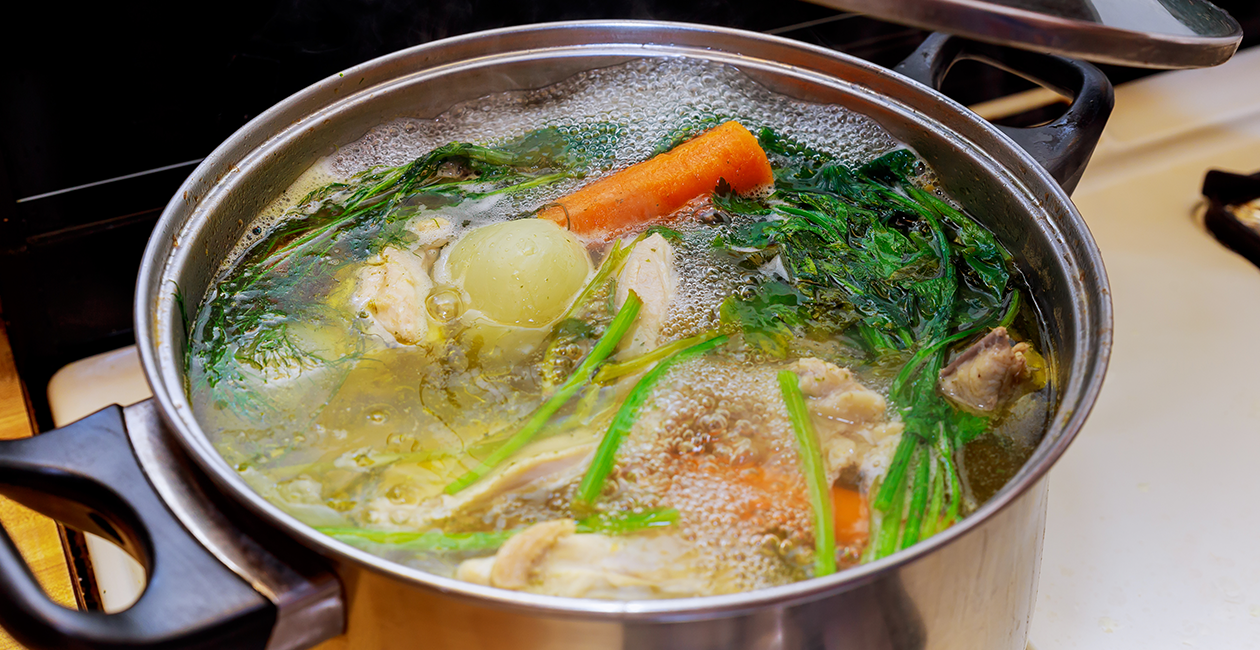 variety of vegetables being boiled in a cooking pot on a stove
