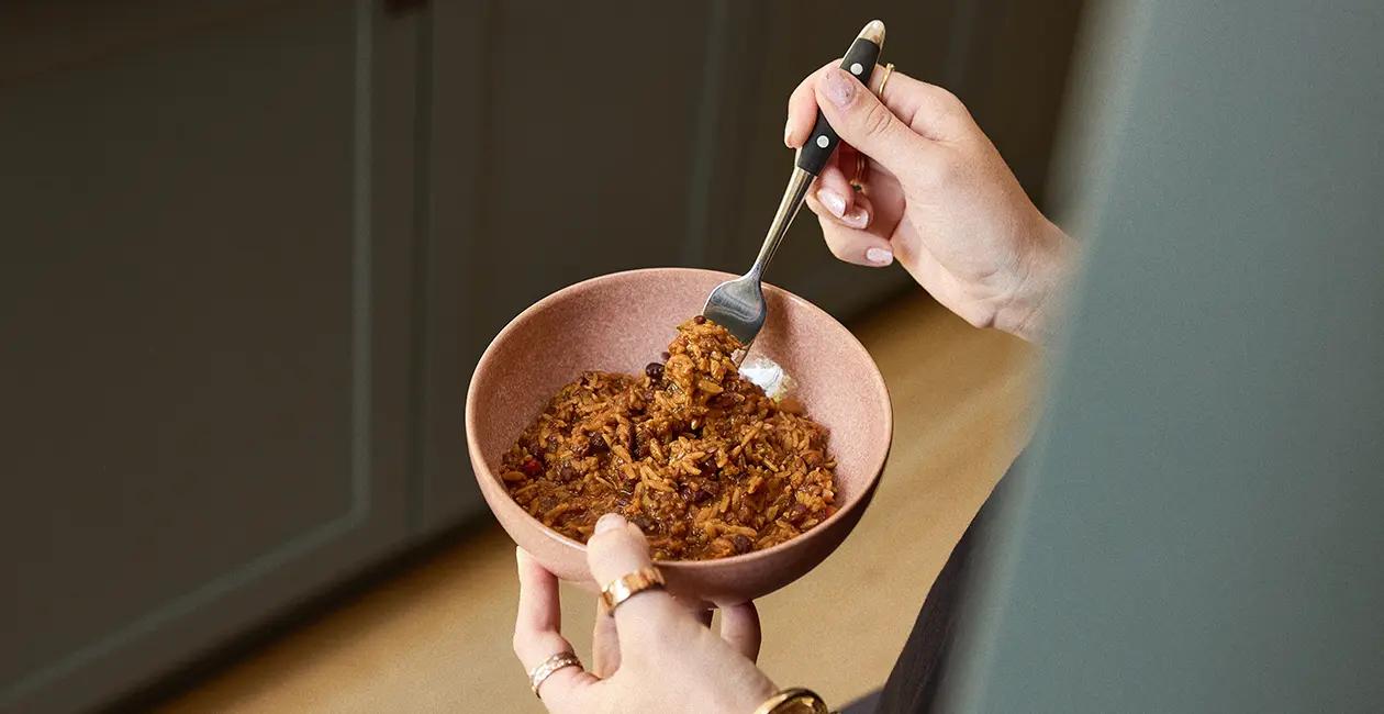 person eating huel hot and savoury from a bowl with a fork