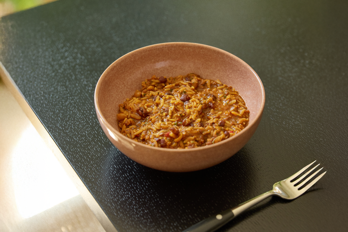 Image of a bowl of Huel on a black kitchen counter with a fork
