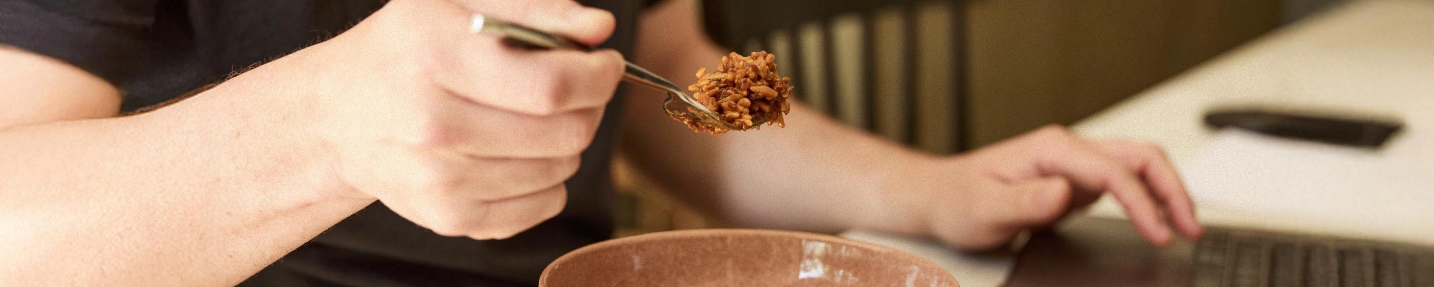man eating Huel Hot and Savoury from a bowl with a fork