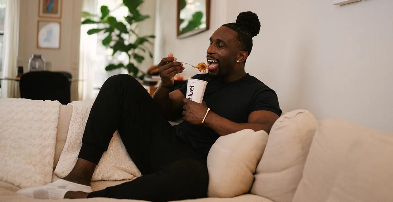 man eating Huel Hot and Savoury from a bowl with a fork