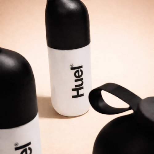 Huel black and white shaker bottles on a neutral background